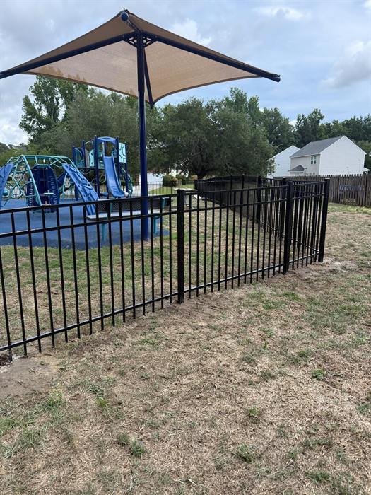 Black aluminum fence around a community playground