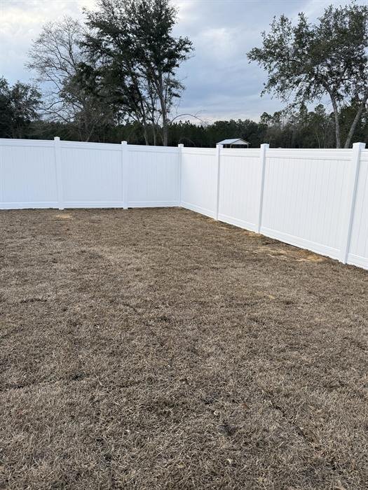 White vinyl privacy fence enclosing a backyard